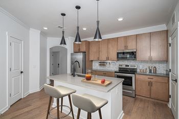 A kitchen with a white countertop and wooden cabinets.